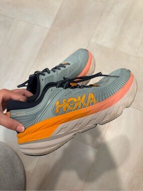 Hoka navy blue running shoe with light blue and orange branding